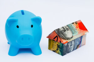 Origami,money,house,next,to,a,blue,piggy,bank